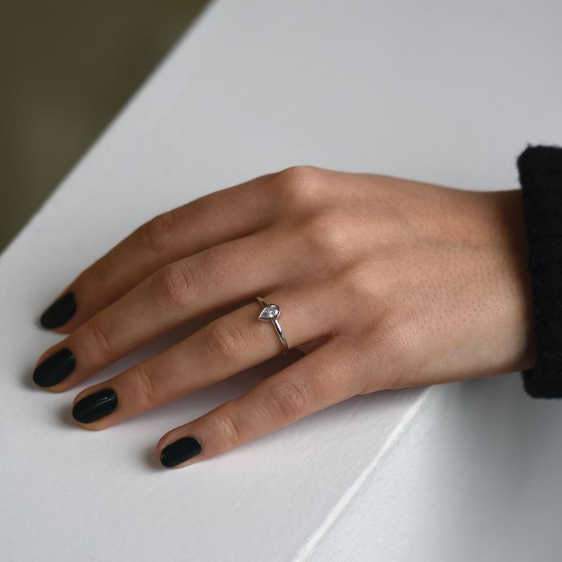 Goldener Ring mit Diamant im Tropfenschliff auf dem Damenhand 49288