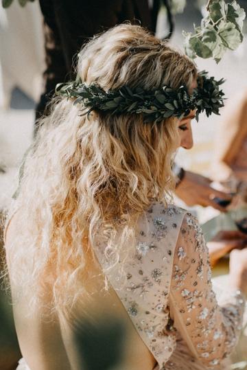 Auf dem Kopf trägt die Braut einen zarten Blumenkranz.