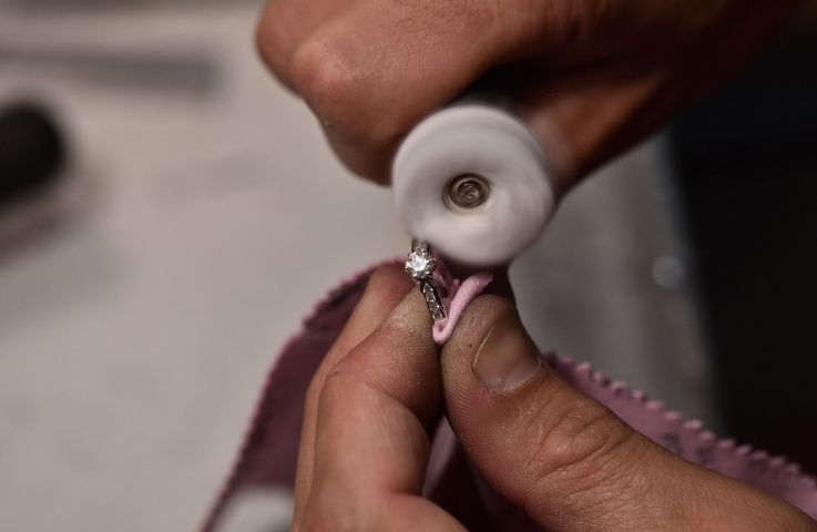 Goldschmied poliert einen Ring in der Werkstatt von Eppi