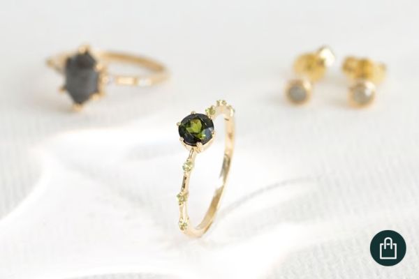 Grüner Turmalin in einem Goldring mit Olivinen