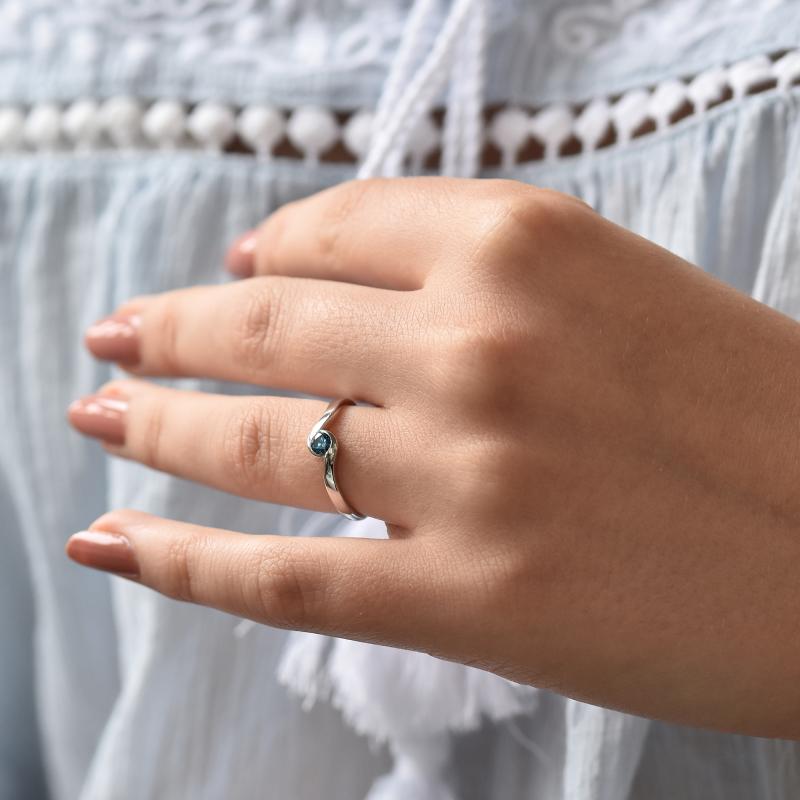 Ring mit blauem Diamanten auf dem Finger