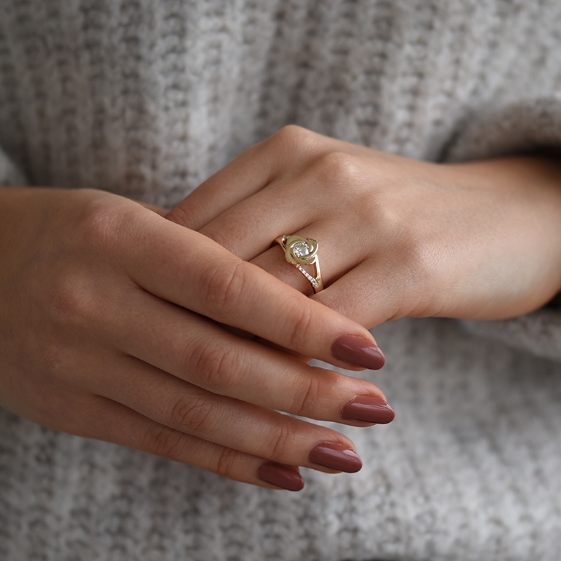 Finger mit Verlobungsring im Form von Rose mit Diamanten 58061