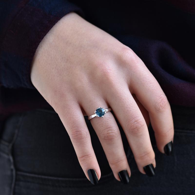 Finger mit Verlobungsring mit blauem Topas 39064