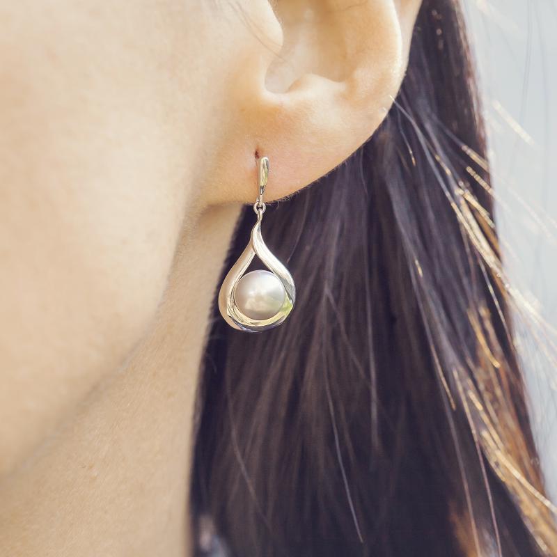 Silberne Ohrringe mit Perle auf dem Ohr 14606