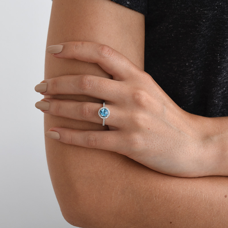 Halo-Stil Ring mit blauem und weißen Topasen auf dem Finger 69346