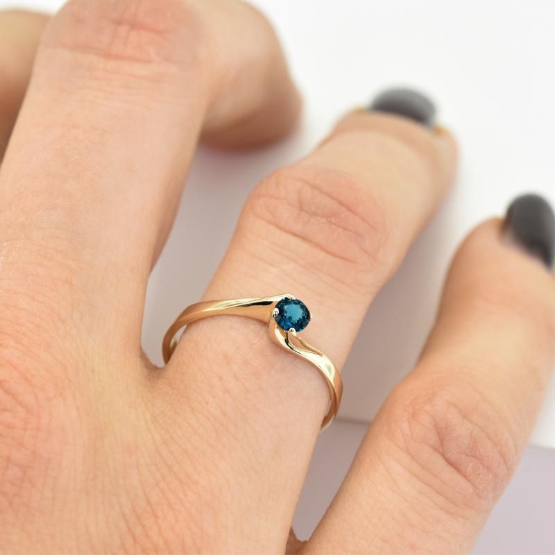Finger mit Verlobungsring und blauem Diamanten 14357