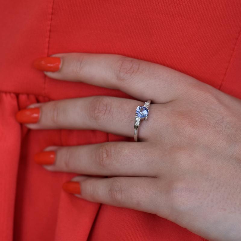 Goldener Ring mit Tansanit und Diamanten auf dem Finger