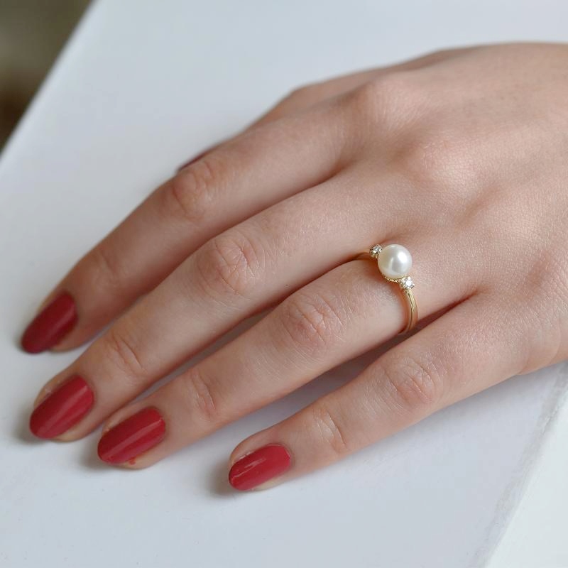 Hand mit weißer Perle Ring 106869